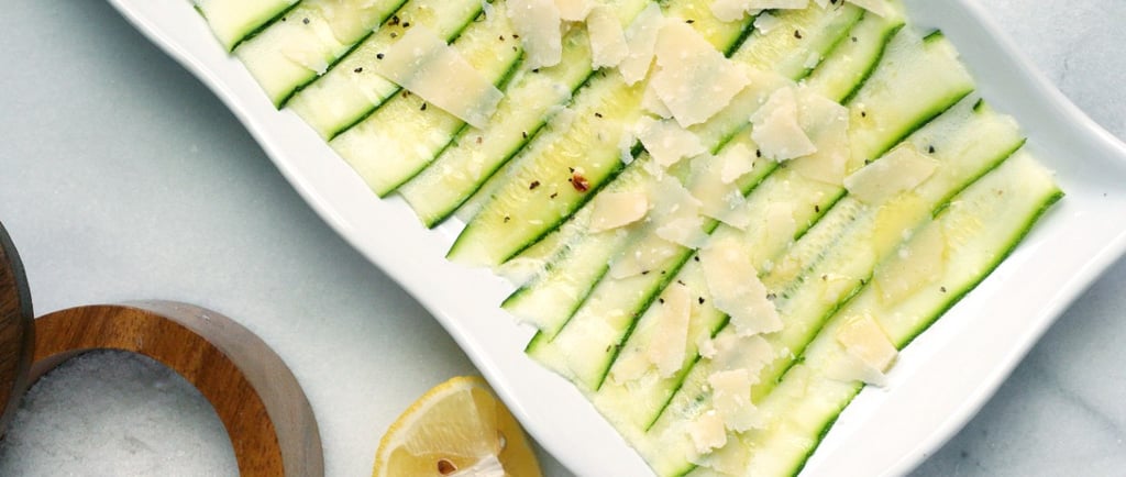 Un plato rectangular blanco con un carpaccio de calabacín