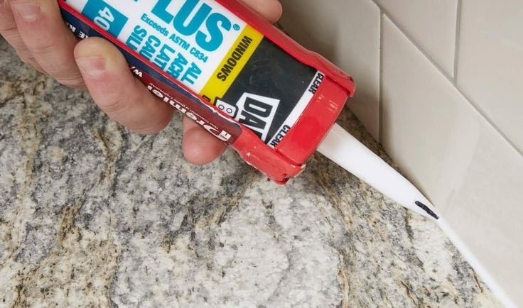 a person holding a tube of glue and a tube of glue