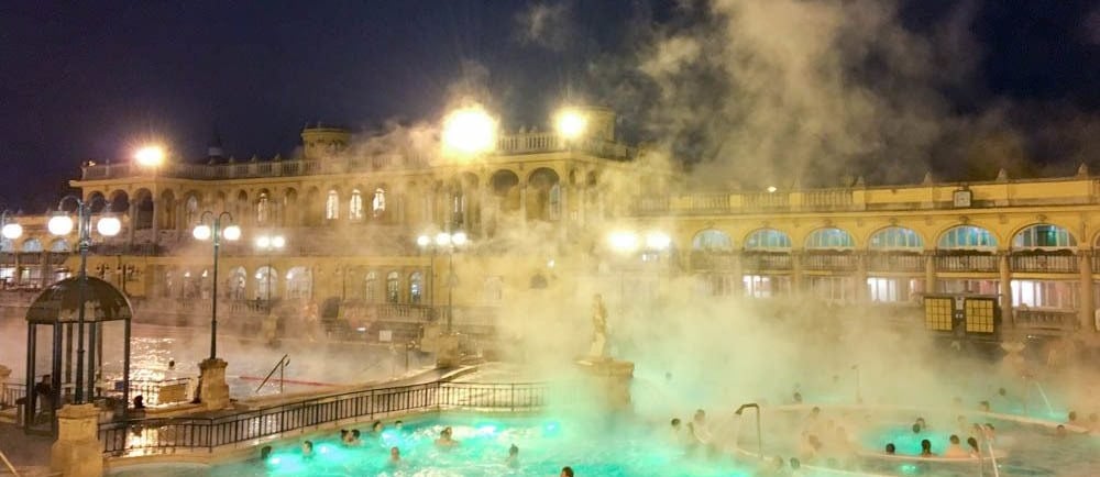 a group of people in a pool with steam coming out of the water