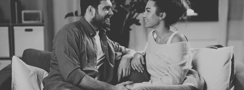 "Couple assis, discutant calmement et consciemment dans leur salon, l'un exprimant un besoin, l'autr