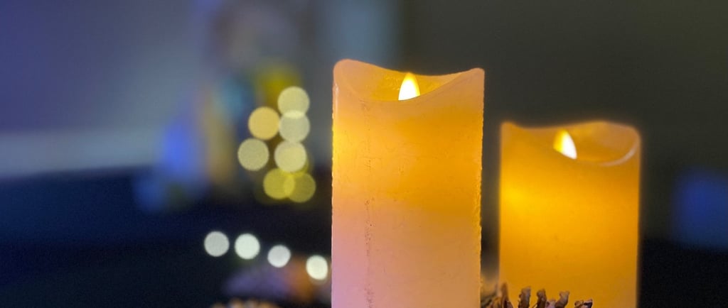 Détail de décoration de mange-debout avec bougies LED effet cire, rondins de bois, pommes de pin, bo