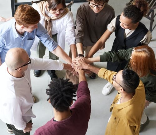 a group of people holding hands in a circle at AA meeting