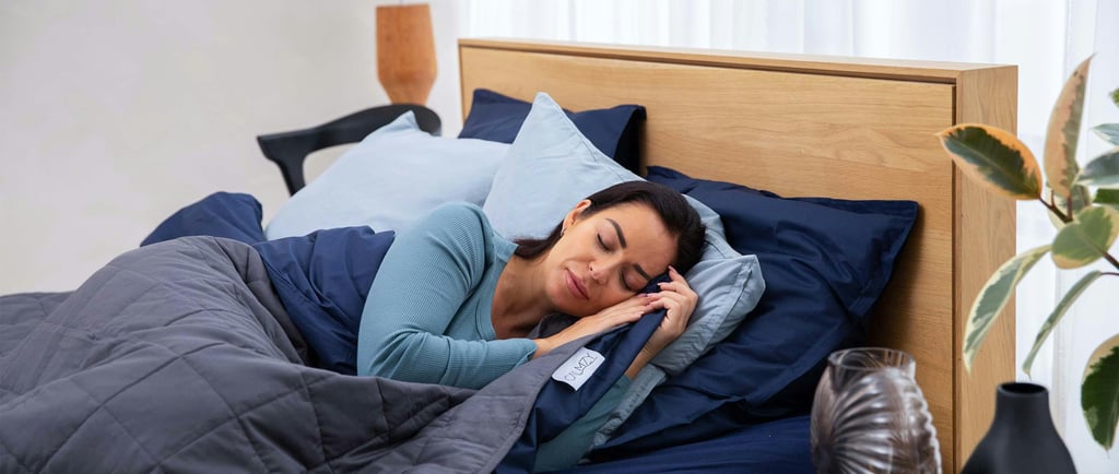 a woman is sleeping in a bed with a phone