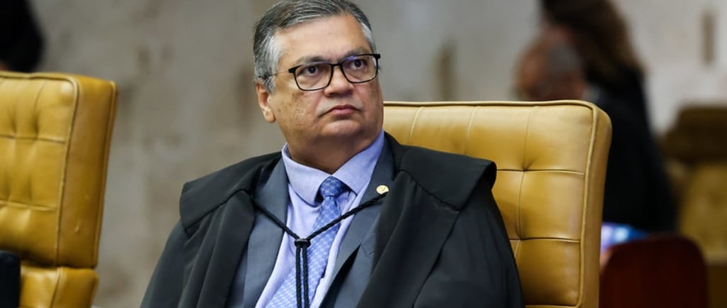 a man in a suit and tie sitting in a chair