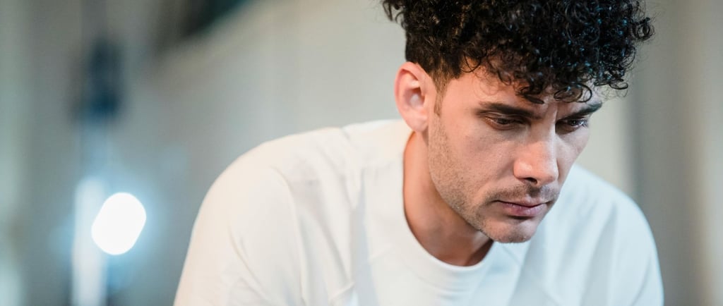 Tamsiaplaukis vyras susirūpinusiu veidu, esantis šviesiame kambaryje