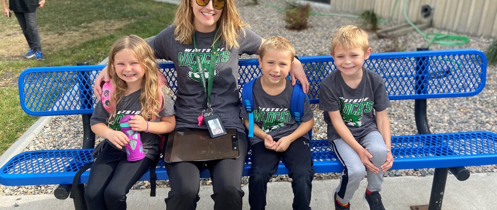 a woman sitting on a bench with three children