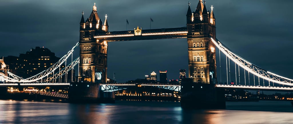 Illuminated Tower Bridge reflecting on the River Thames at night in London