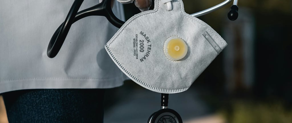 Healthcare worker holding a stethoscope and protective mask