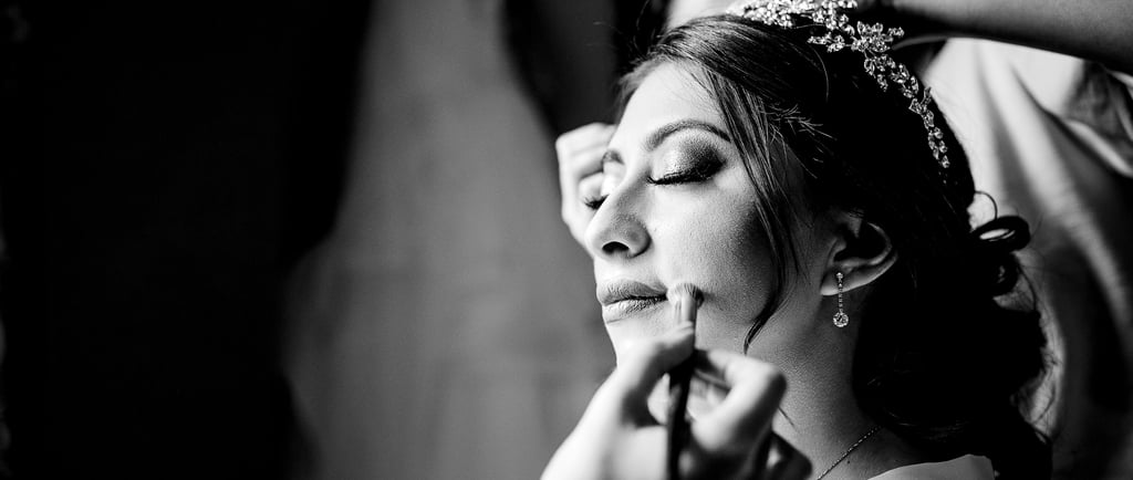 a woman getting her makeup done by a professional makeup artist