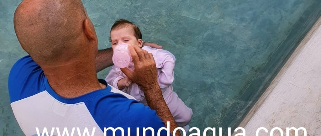 a man holding a baby in a pool