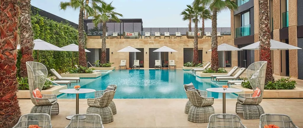Oceanfront pool area at Four Seasons Hotel Casablanca with luxury seating, palm trees