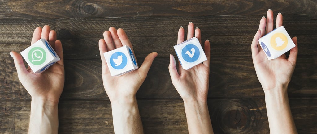 manos sujetando logos de redes sociales