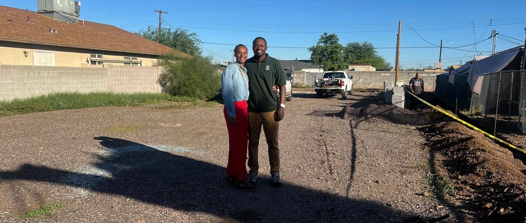 Fred and Tommyka stand next to each other at the development site