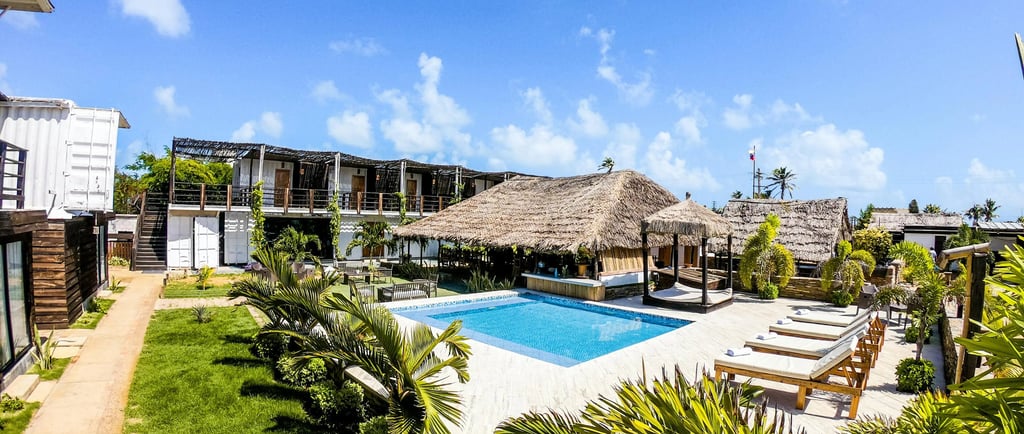 a pool with a thatched roof and a thatched umbrella