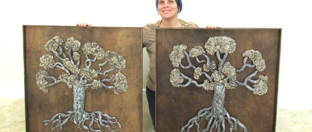 visual artist holding sculpture of trees