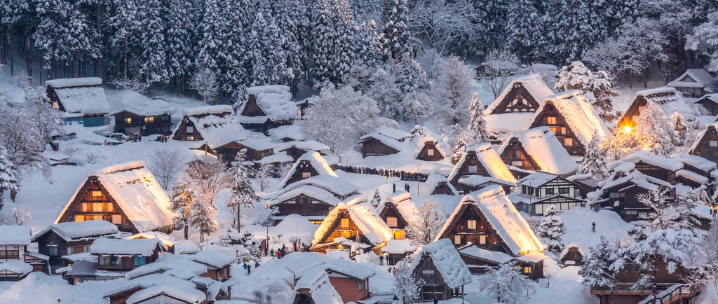 Snow-covered Shirakawa-go village at night with glowing traditional gassho-zukuri farmhouses in Japan.