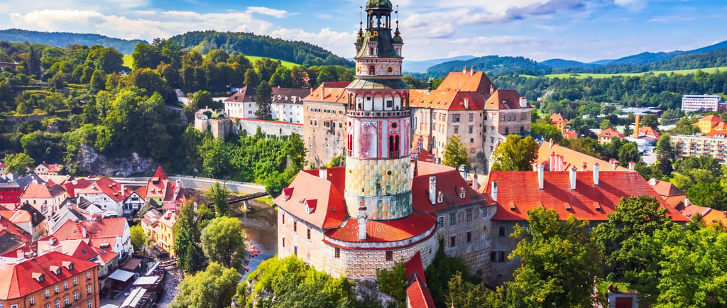 Aerial view of the historic State Castle and colorful round tower in Cesky Krumlov, Czech Republic.