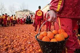 A person holds a bucket of oranges during the Battle of the Oranges festival in Ivrea, Italy.