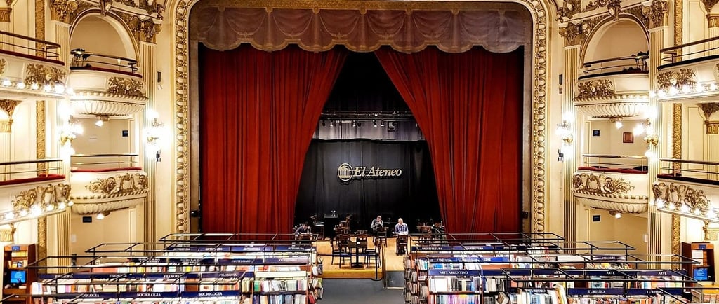 Inside El Ateneo Grand Splendid bookstore in Buenos Aires featuring theater balconies and red stage curtains.