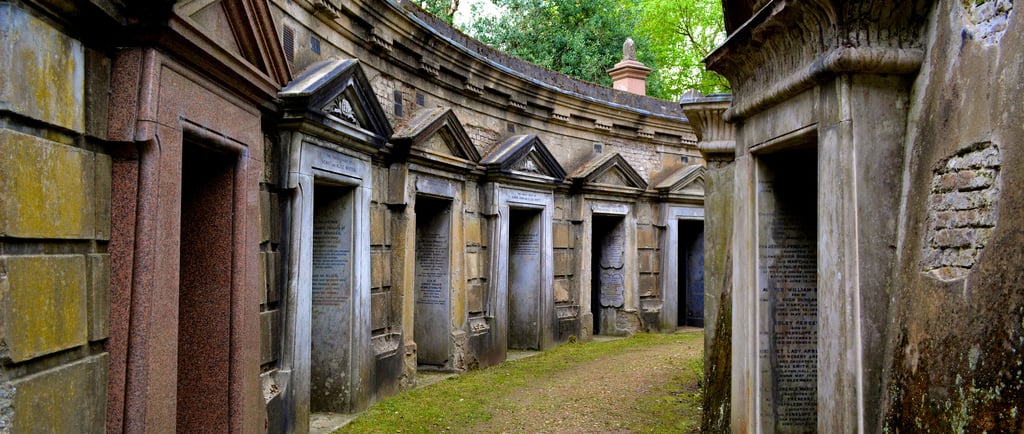 Historic Victorian stone family mausoleums and tombs at Highgate Cemetery in London.