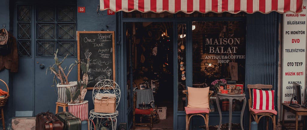 Exterior of Maison Balat antique and coffee shop in Istanbul with a red striped awning and vintage decor.