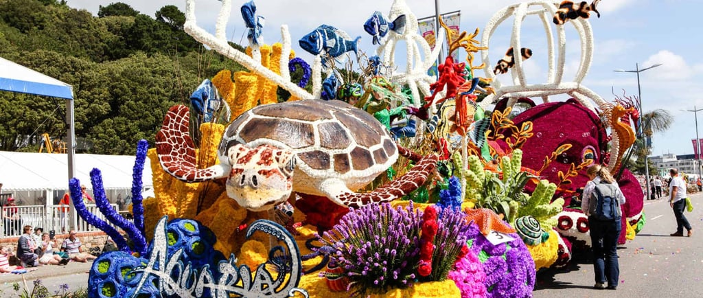 Colorful aquarium-themed parade float featuring a large sea turtle and vibrant coral decorations.