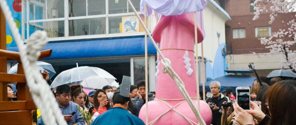 Crowds gather around a large pink phallus float at the Kanamara Matsuri festival in Kawasaki, Japan.