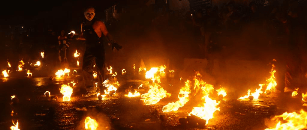A person in a mask performs during Los Bolas de Fuego festival with flaming balls in Nejapa, El Salvador.