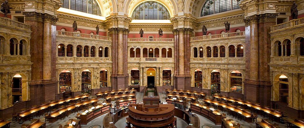 Interior view of the ornate Main Reading Room at the Library of Congress in Washington DC with domed architecture.