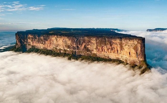 Aerial view of Mount Roraima's flat-topped sandstone tepui rising above a thick sea of clouds.