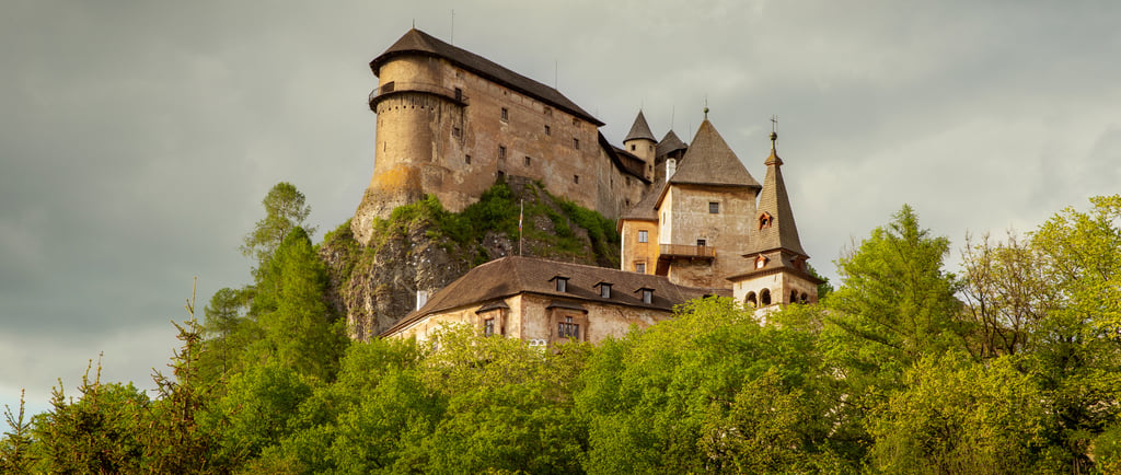 Panoramic view of the historic Orava Castle perched on a high rock cliff in Oravsky Podzamok, Slovakia.