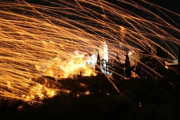 Rocket war fireworks light up the night sky over a church in Chios, Greece during Easter.