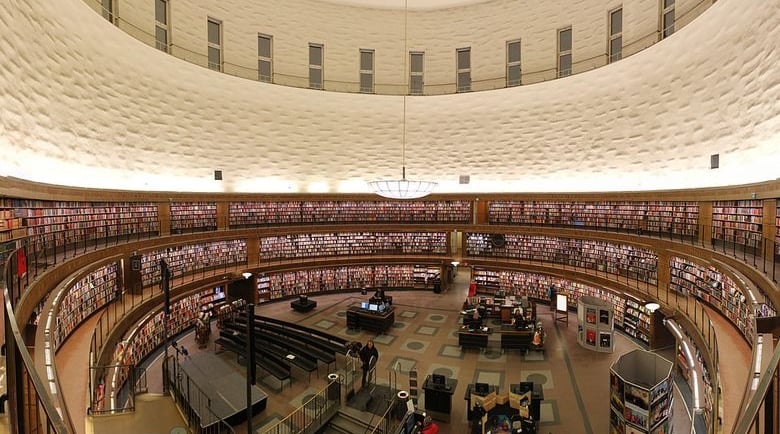 Panoramic view of the circular Stockholm Public Library interior with multi-level bookshelves and rotunda design.