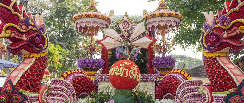 Vibrant Chiang Mai Flower Festival float featuring ornate Naga sculptures and traditional Thai floral displays.