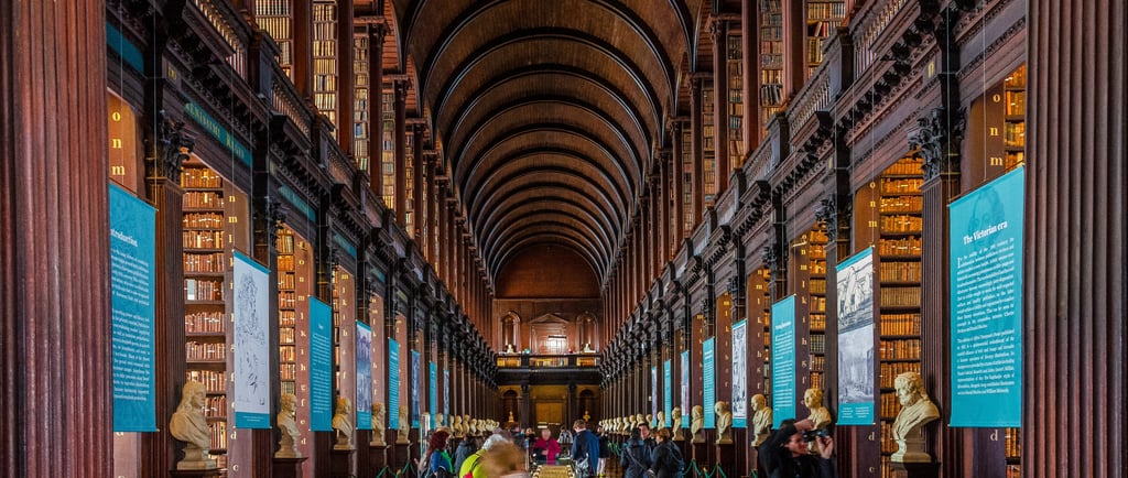 The Long Room at Trinity College Dublin's Old Library with vaulted ceilings and historic bookshelves.