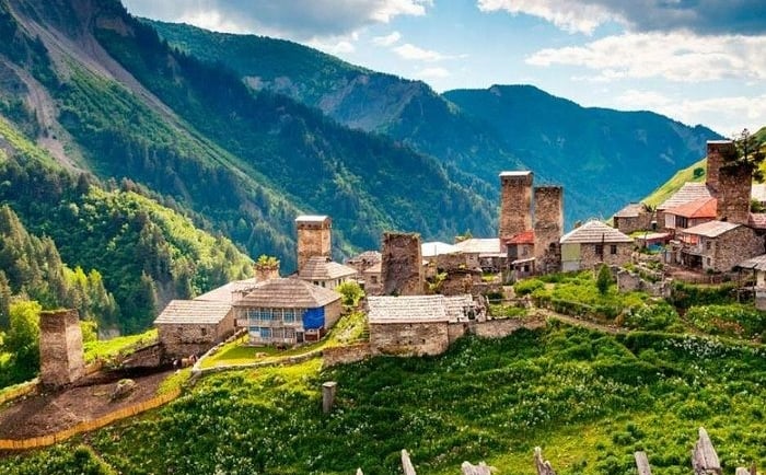 Historic stone Svan towers in a lush mountain village in the Svaneti region of Georgia.