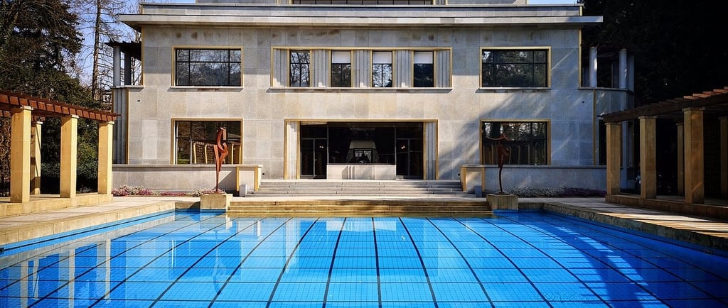 Villa Cavrois art deco architecture featuring a large blue outdoor swimming pool and limestone facade.