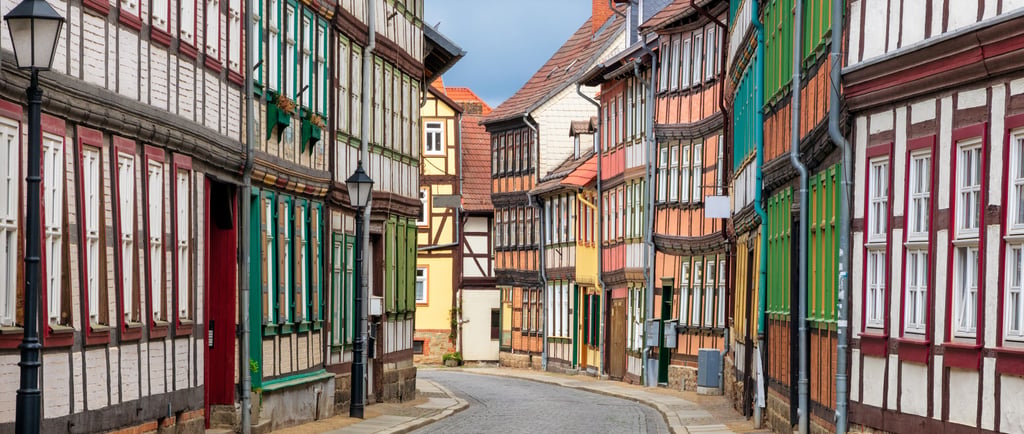 Traditional colorful half-timbered houses lining a cobblestone street in a historic German village.