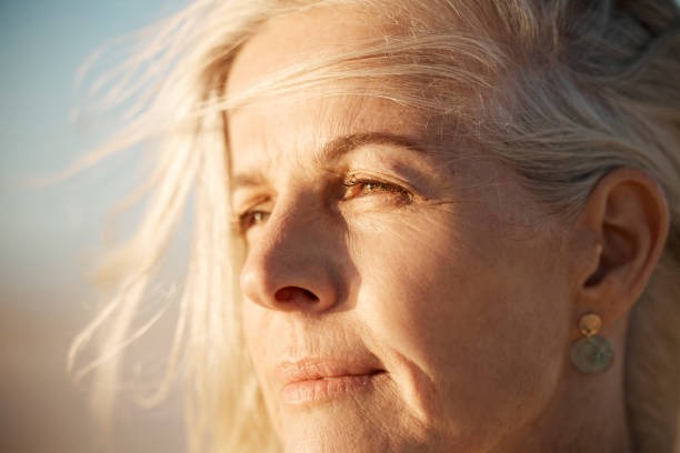 a woman with blonde hair and earrings on her face