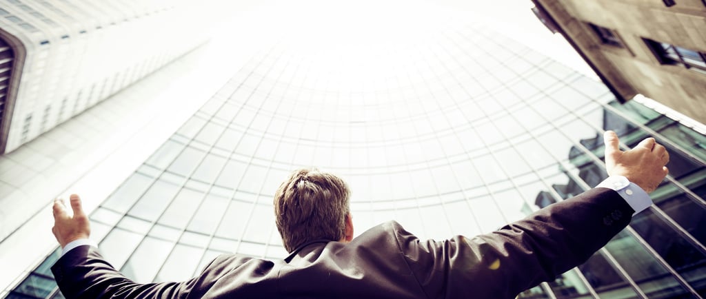 Business executive standing in front of a skyscraper, symbolizing global business growth and success