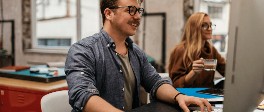 a man sitting at a desk with a woman in a blue shirt