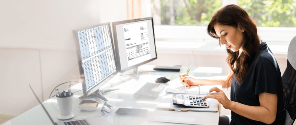 a woman sitting at a desk with a laptop and a laptop