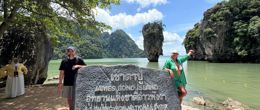 two men standing next to a large rock