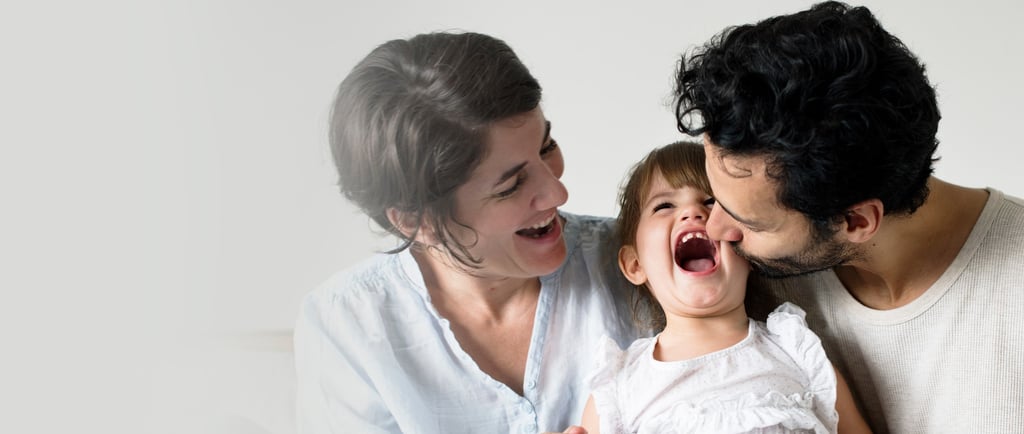 a man and woman and daughter laughing together