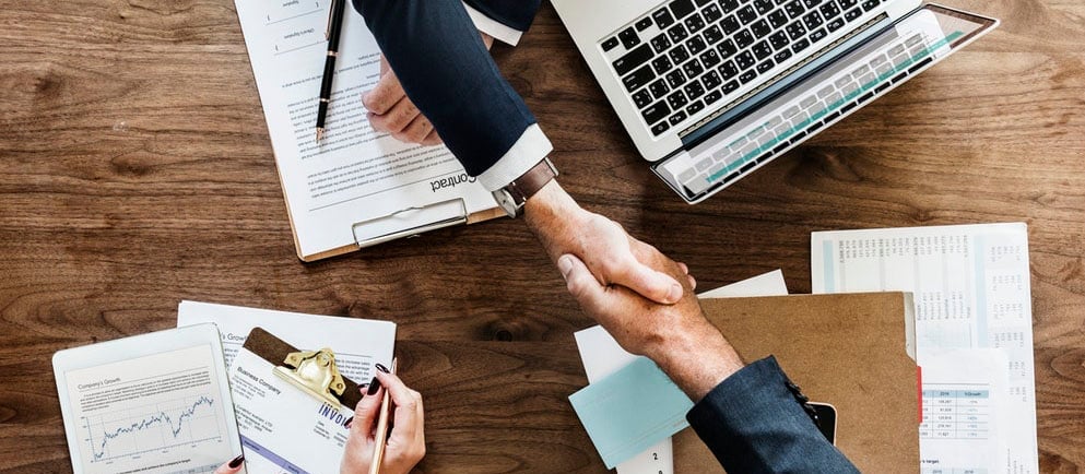 Professional negotiation meeting with salary charts, compensation packages, and handshake representi