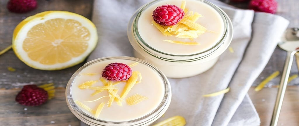 Curd in glass jar with oranges and raspberries