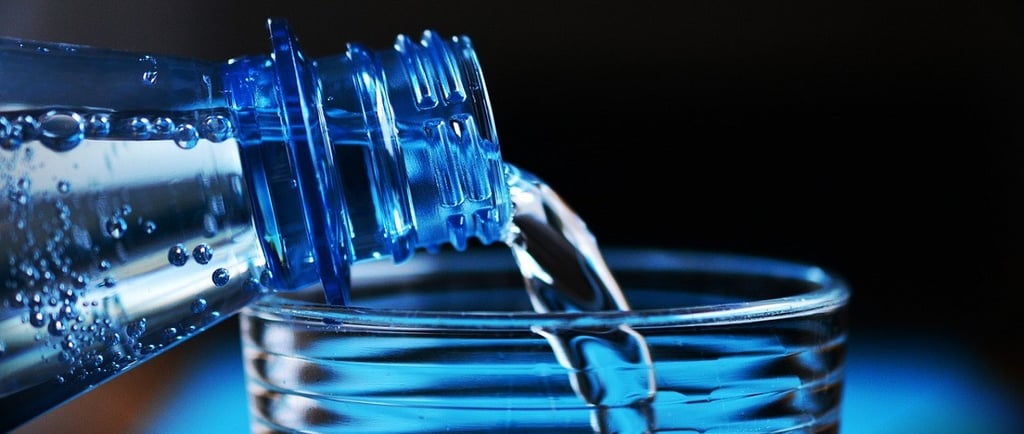 Bottle pouring water into the glass