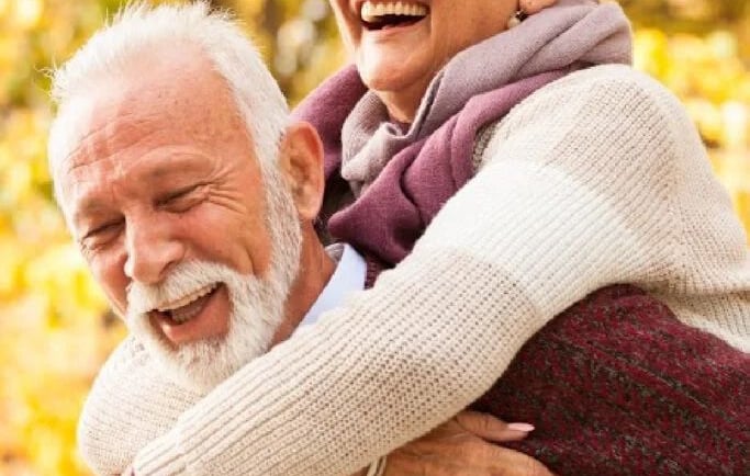 um homem idoso feliz e uma mulher se abraçando no outono