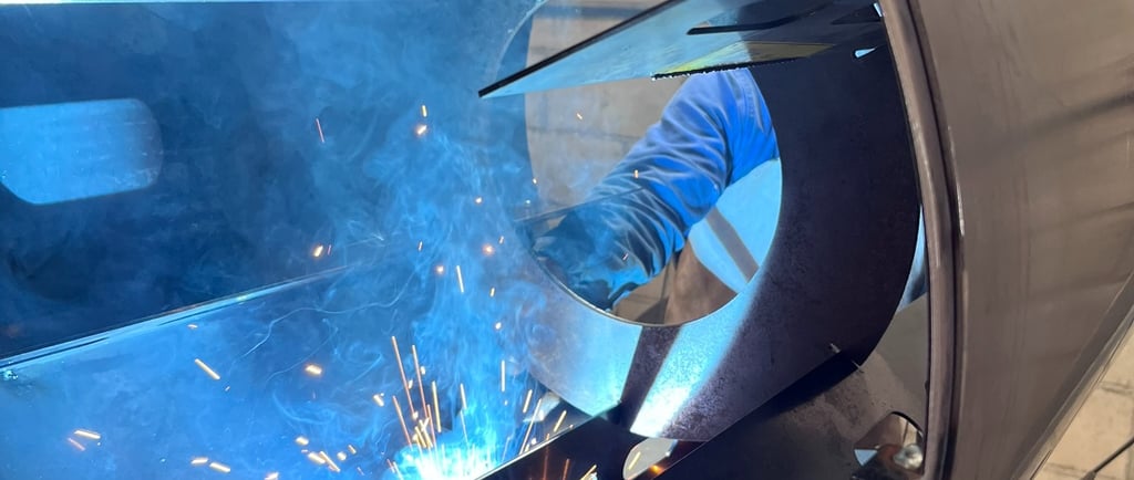 Soldador trabalhando com equipamento de solda TIG em peça de caldeiraria