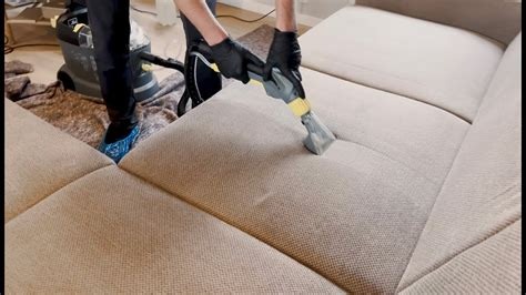 Agent de nettoyage en train de nettoyer un canapé